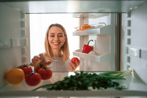 istock Taking the vegetables from fridge. Beautiful young woman is on the kitchen 1478370411