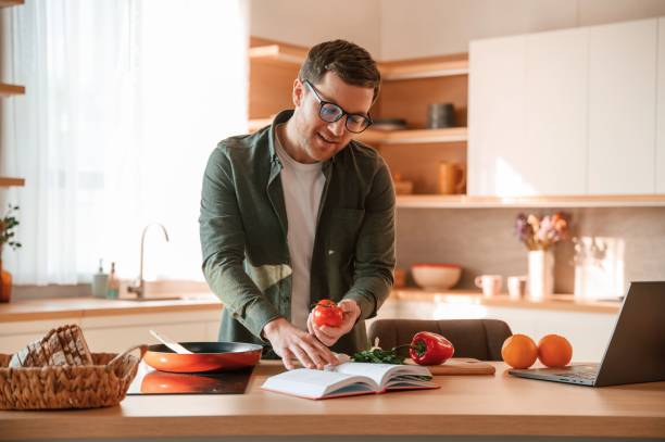 istock Reading receipt and holding tomato. Handsome man is on the kitchen at daytime 1478370579