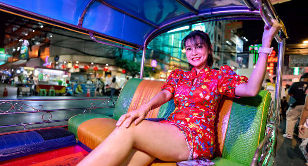 thai woman in tuk tuk wearing cheongsam at yaowarat chinatown bangkok during chinese new year - jinrikisha thailand tuk transportation imagens e fotografias de stock