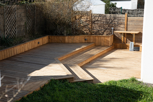 Wooden patio connected to a private building, with seating area and cozy lounge zone.