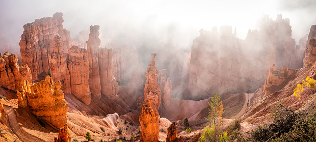 panoramic view of the Navajo loop trail in Bryce Canyon National Park at sunrise with some clouds and fog. Utah, United States of America