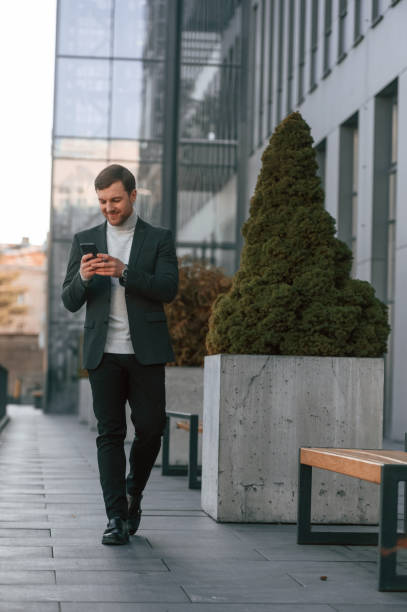 istock Windows behind the handsome man that is in the formal clothes using smartphone 1478373120