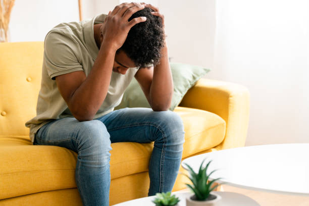 istock Tired black boy sitting on sofa. worried 1478374151