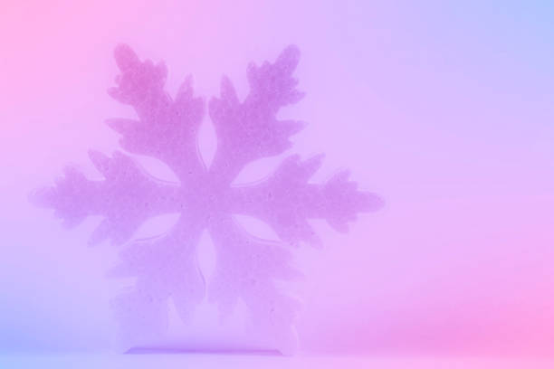 Festive Christmas background. There is a large snowflake on a pink-violet gradient.