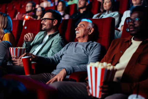 istock Senior man sleeping in movie theater. 1478374873