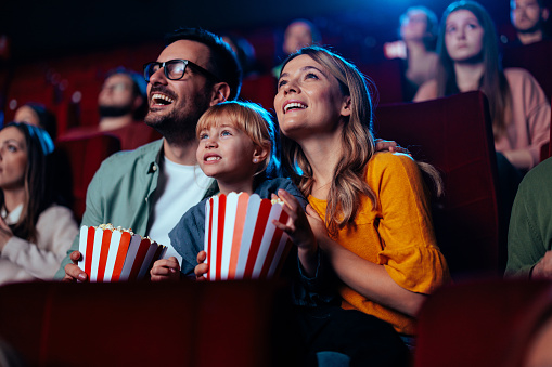 Familia alegre viendo películas en el cine. photo