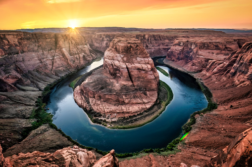 The Horseshoe Bend At Sunset with a sun flare near Page,  Colorado River, Arizona. USA