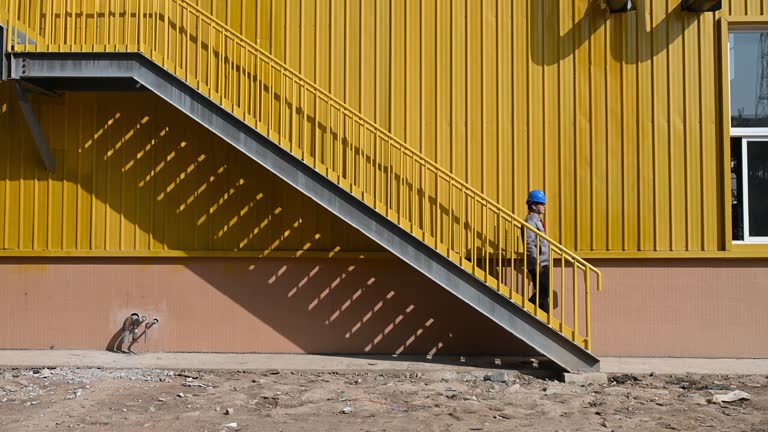 A male worker climbs the stairs in a factory