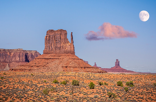 West Mitten Butte with the moon at dawn in Monument Valley tribal park, Arizona, USA