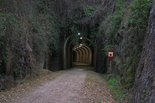Illuminated tunnel in via verde de la Plata, Extremadura Spain, Eurovelo, path with vegetation