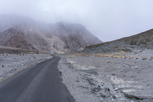 A closeup shot of the mist-clad road through the mountainous area
