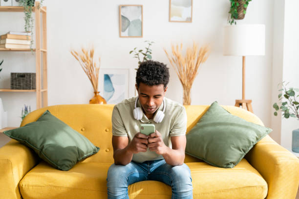 istock Black man using smartphone in living room 1478387419