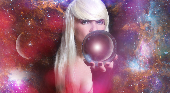 A female psychic with a crystal ball on a galaxy background