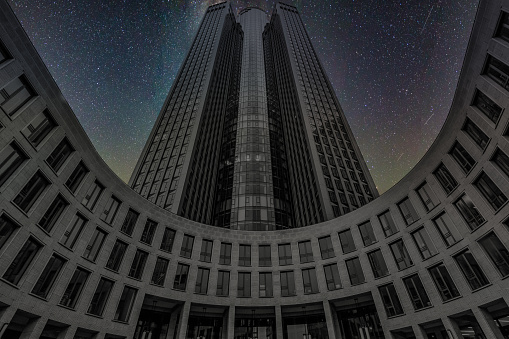 A skyscraper during power failure, without light. View from below into the starry sky. Night Shot