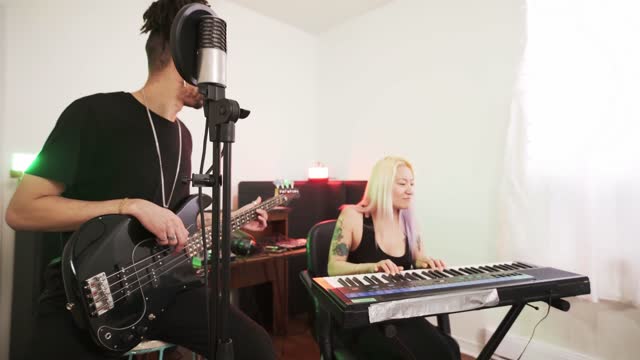 Multi racial Musician couple  practising at home recording studio