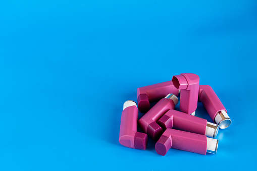 Asthma inhalers on a blue background with a copy space