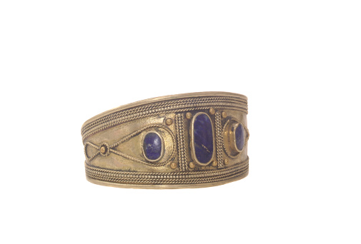 A closeup of a handmade Brass Bracelet From The Middle East on White Background