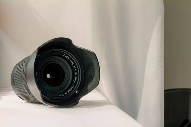 istock Black camera zoom lens on white cloth. 1478392640