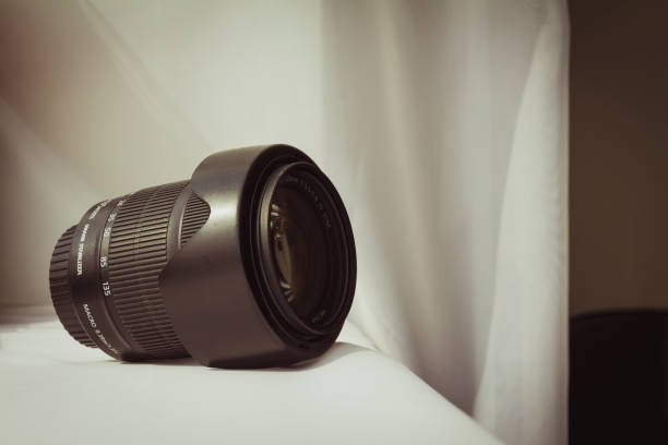 istock Black camera zoom lens on white cloth. 1478392643