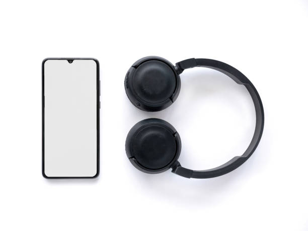 istock Black wireless headphone and mobile phone with a blank screen mockup on a white background 1478392683