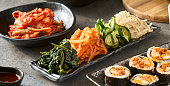 plate of assorted korean kimchi and pickled vegetables at dinner table