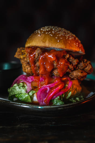 istock Vertical closeup of a burger on a dark plate in a low lighting 1478397966