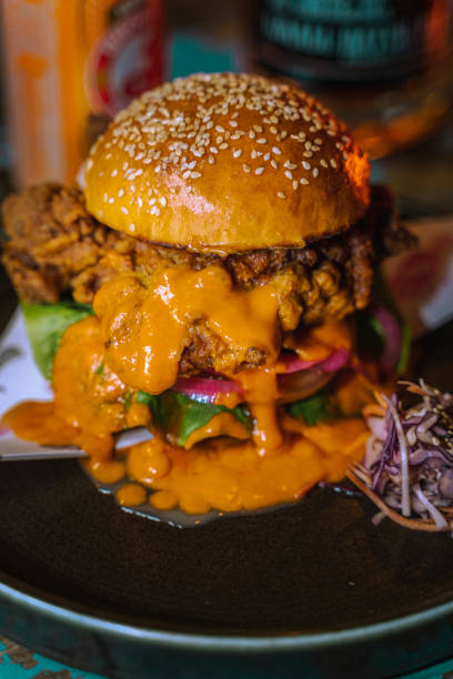 istock Vertical selective focus of a burger dripping with sauce on a dark plate 1478397968
