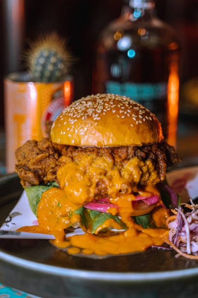 Vertical selective focus of a burger dripping with sauce