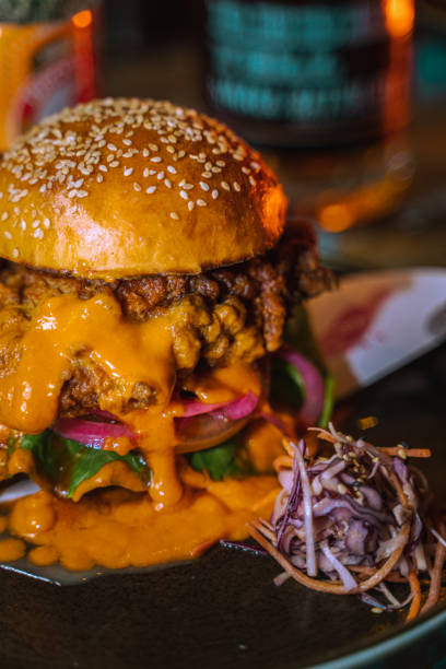 istock Vertical shot of a chicken burger in a dark grungy restaurant setting 1478397979