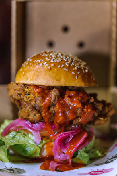 istock Vertical shot of a chicken burger in a dark grungy restaurant setting 1478398002