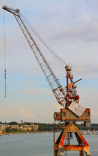 A vertical shot of a harbor crane on a sunny day in summer