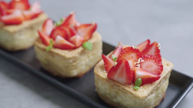 Hand bringing Strawberry cheese tart to table
