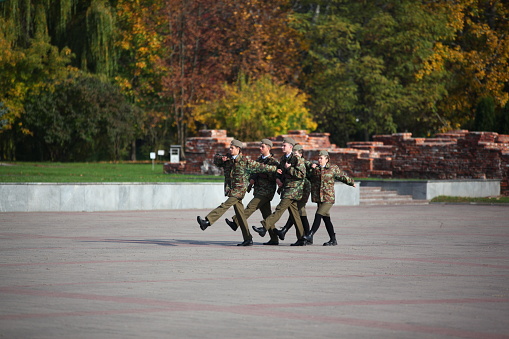 Young cadets in military uniforms are marching in the ranks to the memorial post. Belarus, Brest, October, 2022.