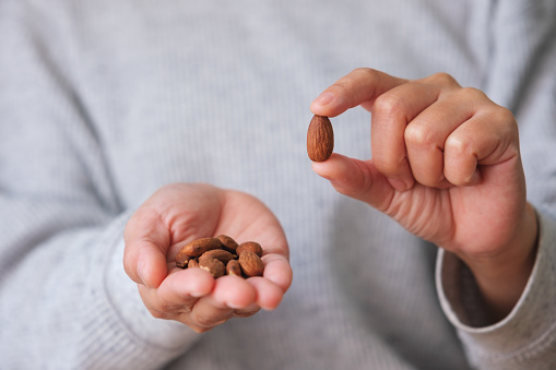 Closeup image of hands holding and showing almonds