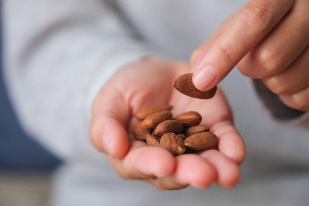 istock Closeup image of hands holding and picking up almonds 1478404286