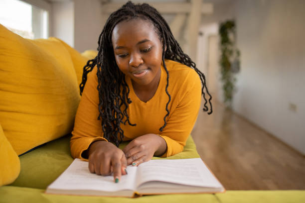 istock Woman reading book at home 1478405200