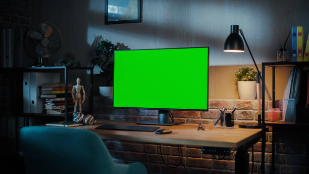 istock A Modern Personal Computer Monitor with Chroma key Green Screen Display Standing on the Desk of a Cozy Home Office. Living Room Created by Interior Designer with Good Taste and Style. 1478406532