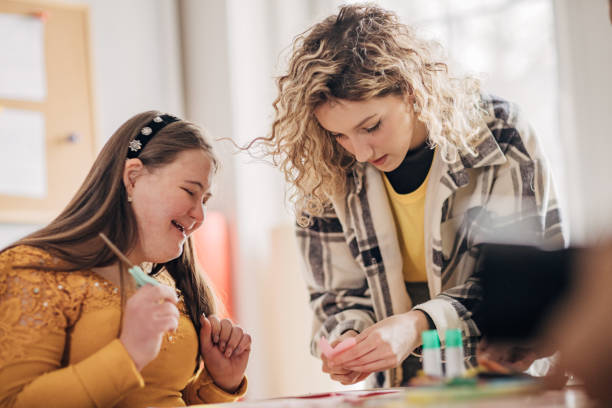 istock People with down syndrome and cerebral palsy doing an art project with help with assistants and animators.Disability health care art workshop. 1478407462
