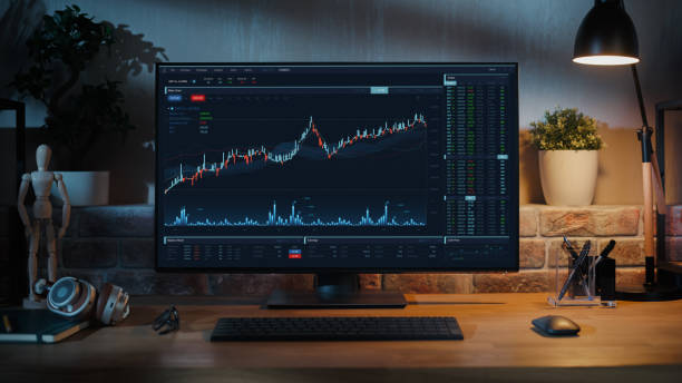 istock Desktop Computer Monitor Standing on a Wooden Desk with Height Adjustable Function. Economic Charts and Statistics Displayed on Screen at Home in Modern Living Room or Creative Loft Office 1478407896