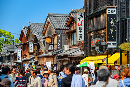 Ise, Japan - April 25, 2014: Crowds walk on the historic shopping street of Oharai-machi. The reconstructed buildings are completed in the Edo period traditional style.