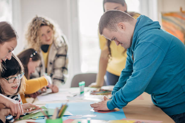istock People with down syndrome and cerebral palsy doing an art project with help with assistants and animators.Disability health care art workshop. 1478409172