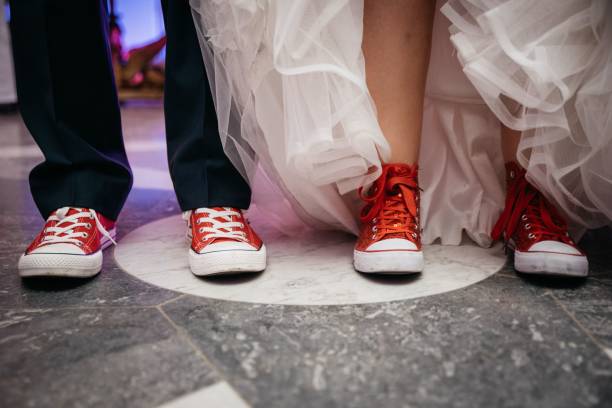 istock Bride and the groom, standing side by side wearing red sport shoes 1478409787