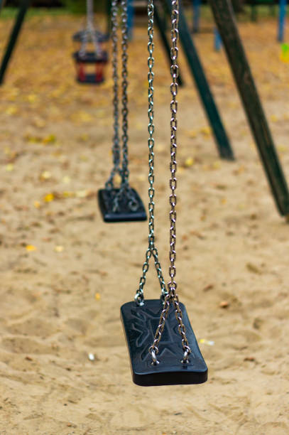 istock Vertical selective focus shot of swings in a sandy playground 1478411527