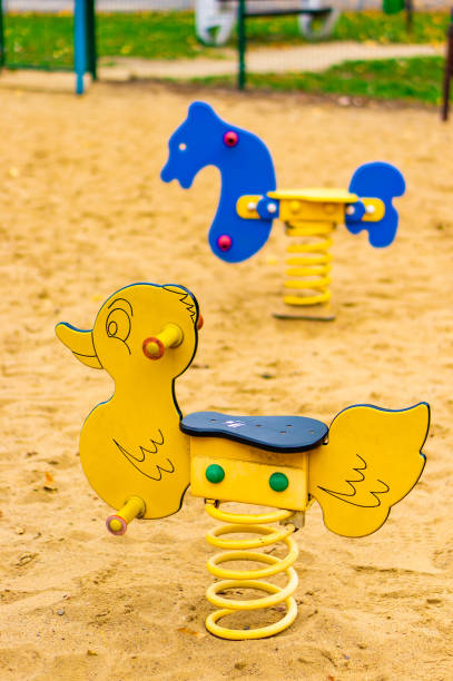 istock Vertical selective focus shot of spring rockers in a sandy playground 1478411530