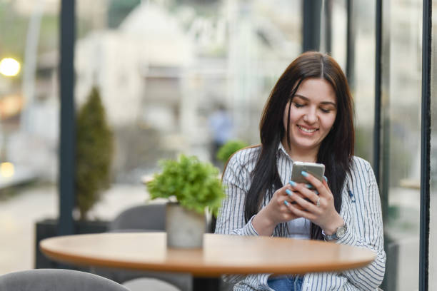 istock Smiling Female Relaxing In Coffee Bar And Using Smartphone 1478412420