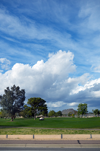 Spring weather front moves in over city golfcourse as seen from a public street, Phoenix, Arizona