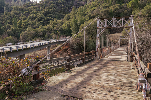 Colfax, California, United States – January 02, 2021: The historic bridge and modern traffic bridge stand beside each other at Mineral Bar recreation area in Auburn Ravine State Park.