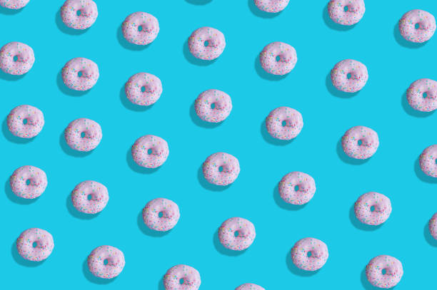 istock Top view of a glazed donut pattern isolated on a blue background 1478416614