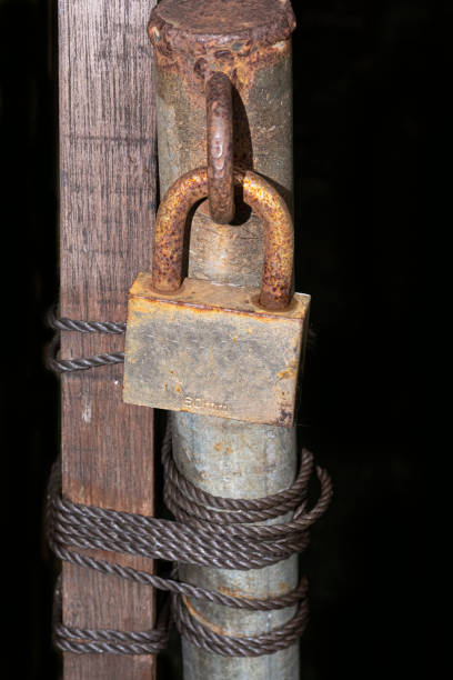 istock Rusted padlock on old metal pole with twisted rope 1478419340