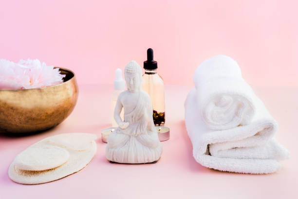 istock White Buddha and spa wellness massage set for relaxing with essential oils. Alternative medicine and body care. Tibetan singing bowl with floating peony flower for sound healing. Exotic massage. 1478421502